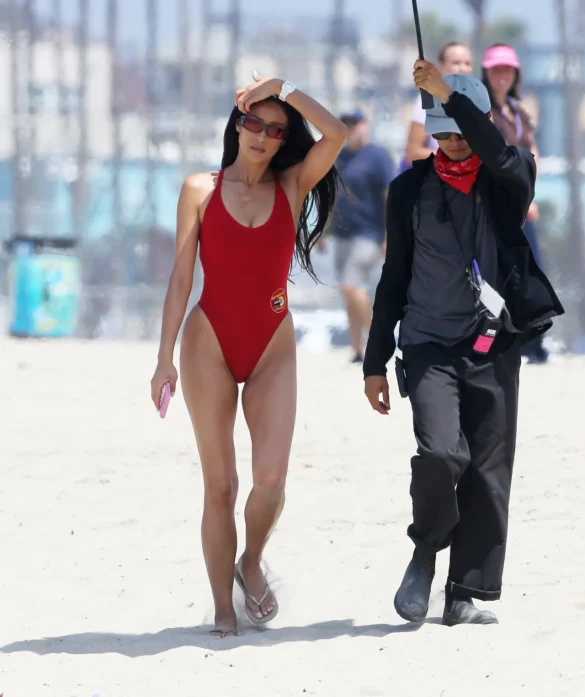 shay-mitchell-films-baywatch-in-a-red-swimsuit-july-2026-0 Shay Mitchell Films Baywatch in a Red Swimsuit July 2026