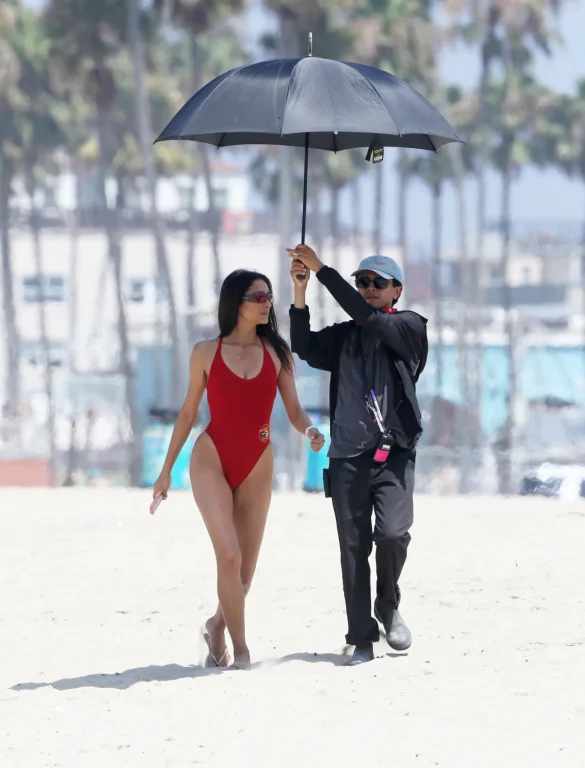 shay-mitchell-films-baywatch-in-a-red-swimsuit-july-2026-1 Shay Mitchell Films Baywatch in a Red Swimsuit July 2026