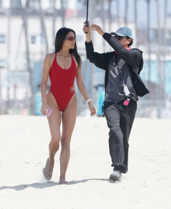 shay-mitchell-films-baywatch-in-a-red-swimsuit-july-2026-3 Shay Mitchell Films Baywatch in a Red Swimsuit July 2026